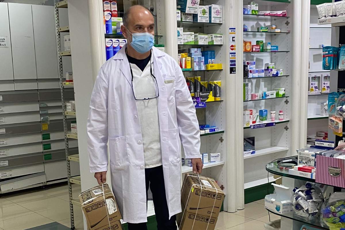 Gonzalo Nozal Fenández, farmacéutico comunitario en Granada, con dos cajas de nutrición enteral que acaba de preparar para llevárselas a domicilio a un paciente traqueostomizado con movilidad reducida.